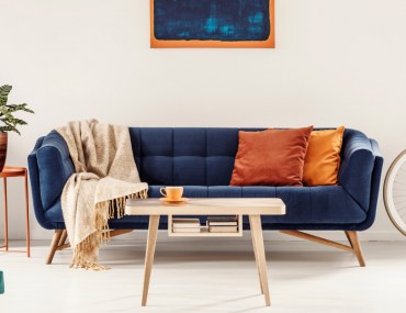 Yellow and blue painting above sofa in colourful living room